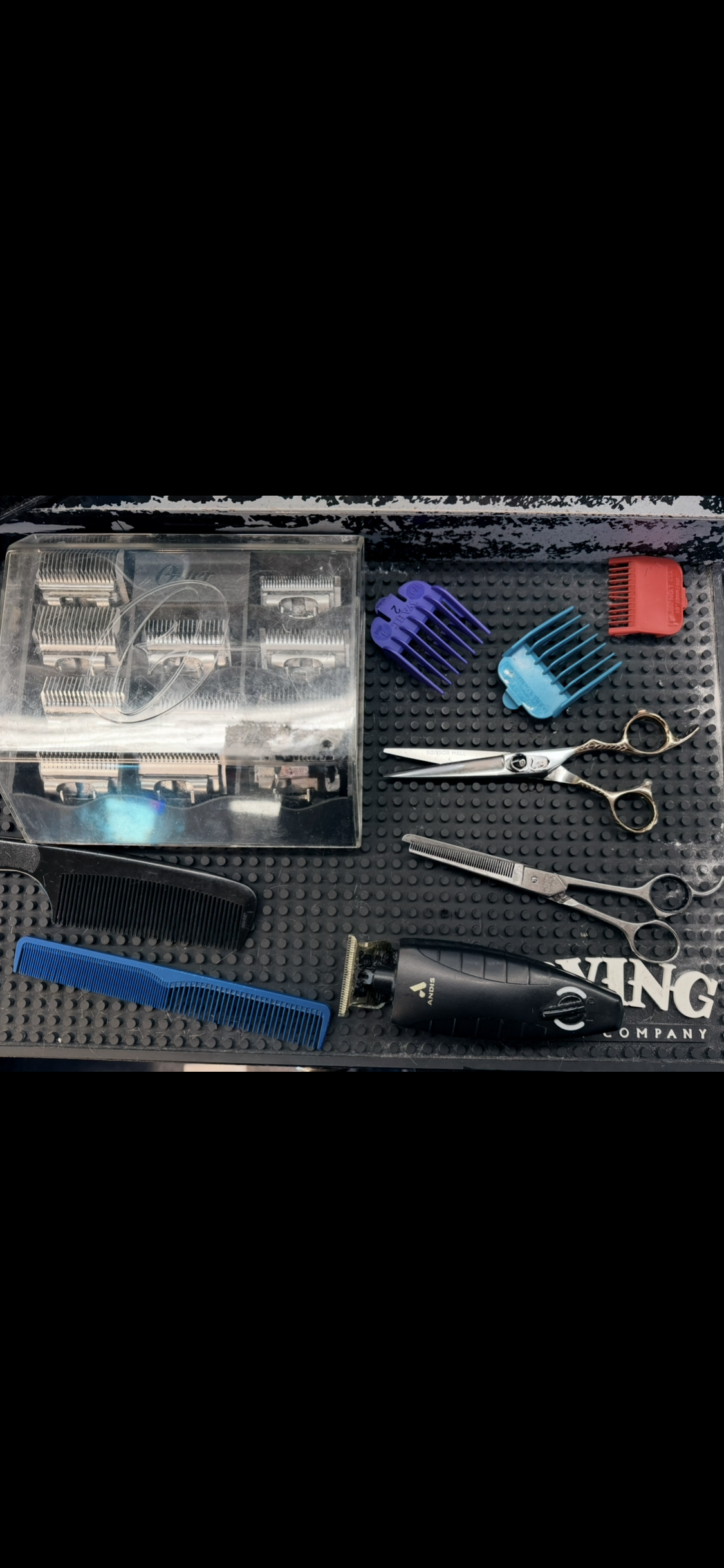 Barber tools laid out: clippers, shears, combs, and guards